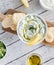 A top down view of a bowl of Tzatziki dip with pita naan bites ready for eating.