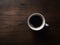 Top Down View of a Cup of Hot Coffee Sitting on a Wooden Table