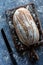 Top down view of a decorated sourdough bread loaf on a wooden board.