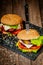 Top down view of delicious burgers with beef, cheese, tomato, lettuce with knife. Selective focus