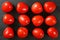 Top down view, dozen of mini tomatoes arranged on black stone desk