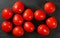 Top down view, dozen of mini tomatoes on black stone desk