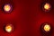 Top down view of earthen lamps burning against red background