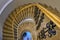 Top down view of elegant, golden, spiral staircase