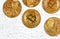 Top down view, golden commemorative btc - bitcoin cryptocurrency - coins scattered on white stone board, closeup detail