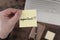 top down view of hand holding yellow sticky note with word IMPORTANT