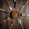 A top down view of a haphazard arrangement of wooden spoons filled with spices used to make a southwest spice blend.
