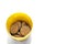 Top-Down View of Herbal Supplement Pills in a Yellow Plastic Container on White Background