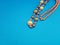 A top down view of an old hand-crafted bead jewelry necklace on a blue background