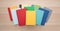 Top down view of a pile of bright colorful books centered on a light wood desk