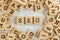 Top down view, pile of square wooden blocks with letters SEO stands for Search Engine Optimization on white board