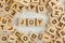 Top down view, pile of square wooden blocks with word JOY on white board