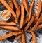 Top down view of a pile of sweet potato fries with habanero aioli for dipping.