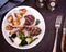 Top down view of a plated grilled lamb chops meal with potatoes and vegetables.