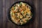 Top down view of a round baking pan filled with loaded nachos ready for sharing.