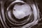 Top-down View of Square Bottom of Empty Beer Glass on Dark Table Surface. Bubbles Left from the Beer Head or Collar, Frothy Foam