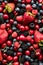 A top down view of a variety of berries and cherries in a pile.