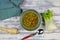 Top down view on white wood table with red spoon, fennel and parsley root, blue napkin and bowl homemade winter minestrone root