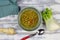 Top down view on white wood table with red spoon, fennel and parsley root, blue napkin and bowl homemade winter minestrone root