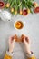 Top down view of a woman holding a stroopwafel (Dutch syrup waffle)  with cup of tea and tulips on grey background