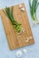 Top down view of a wooden cutting board with chopped green onion on it. Prebiotic foods concept.