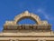 Top frontispiece of the Roman Temple of Diana well-preserved Corinthian style marble cornice under a clear blue sky. Merida