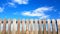 top half of a frontal wooden fence against blue sky