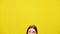 Top of head of young redhead woman at bottom with yellow background. Eyes of slim Caucasian woman looking up at colored