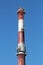 Top of high industrial red and white chimney with multiple cell phone antennas