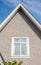 Top of the house with dormer in the blue sky. Houses with shingle roof. Edge of roof shingles on top of the house