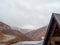 The top of a house located in the highlands overlooking the highway and the clouds descending on the mountain peaks