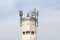 Top of large concrete industrial complex tower with multiple cell phone antennas and transmitters surrounded with security cameras