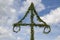 Top of a midsummer pole at sky with white clouds