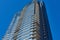 Top of a modern residential skyscraper in Greenpoint, NYC, silhouetted against a blue sky