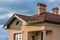 Top of new big modern house with shingled red roof, two high chi