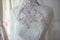Top part of a gorgeous classic wedding dress with transparent embroidered lace corset set on a vintage mannequin torso