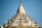 The top part of Swe Taw Myat Pagoda against a blue sky in Yangon