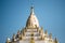 The top part of Swe Taw Myat Pagoda against a blue sky in Yangon