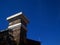 TOP OF PILLAR ON ENTRANCE TO AN OLD FORT AGAINST BLUE SKY