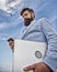 Top qualities of excellent manager. Man well groomed bearded hipster holds laptop blue sky background. Guy formal suit