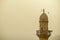 Top of a red sandstone minaret with loudspeakers for the call to prayer