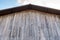 Top roof of old weathered wooden barn against dramatic sky