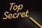 Top secret words written with yellow pen on black background. Business concept