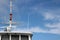 Top of a ship with mast with blue sky and cirrus clouds