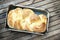 Top shot, close up of fresh baked homemade vegan braided loaf on a wooden, rustic table background, home baking, minimal Easter