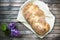 Top shot, close up of fresh baked homemade vegan braided loaf on a wooden, rustic table background, home baking, minimal Easter