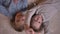 Top shot portrait of two small funny girls watching gladly into camera lying on the floor.