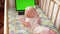 Top slow motion of cute baby boy crowling to the laptop with chromakey screen