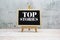 Top Stories word on blackboard stand on wooden background