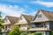 Top of three residential houses on blue sky background.